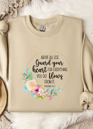 a beige sweatshirt with a floral design and text printed on it, along with a coffee mug and some decorative elements such as a snowflake and a branch.