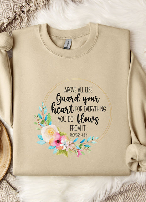 a beige sweatshirt with a floral design and text printed on it, along with a coffee mug and some decorative elements such as a snowflake and a branch.