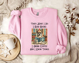A pink sweatshirt with a graphic design of a dog wearing glasses and holding a book, along with text that says "Thats what I do I read books I drink coffee and I know things".