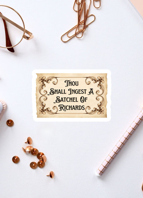 a sticker with a quote, surrounded by various office supplies such as pens, a notebook, and a pair of glasses.