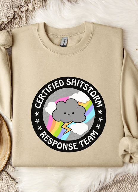 a beige sweatshirt with a graphic design on it, along with a mug, a snowflake, and some flowers.
