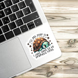 A sticker with a cartoon turtle and the text "I'll get over it, I just have to be dramatic first" is placed on a laptop keyboard.