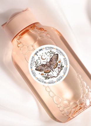a close up of a bottle with a butterfly on it