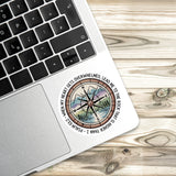 A sticker with a compass and a Bible verse is placed on a laptop keyboard.