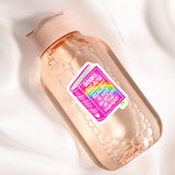 A pink bottle with a sticker that says "Books because reality is optional" and has a rainbow design.