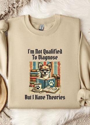 a beige sweatshirt with a printed design of a cat wearing glasses and surrounded by books, along with the text "I'm Not Qualified To Diagnose But I Have Theories".