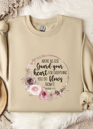 a beige sweatshirt with a floral design and text printed on it, along with a coffee mug and some decorative elements such as a snowflake and a branch.