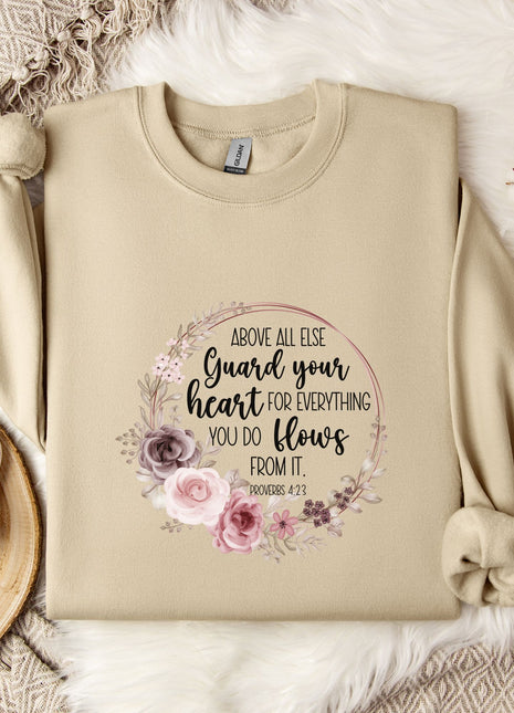 a beige sweatshirt with a floral design and text printed on it, along with a coffee mug and some decorative elements such as a snowflake and a branch.