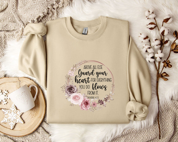 a beige sweatshirt with a floral design and text printed on it, along with a coffee mug and some decorative elements such as a snowflake and a branch.