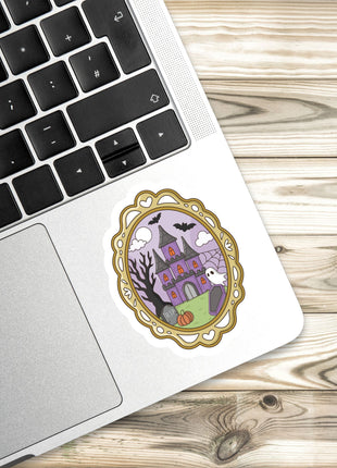 a sticker of a castle on a laptop keyboard, placed on a wooden surface.