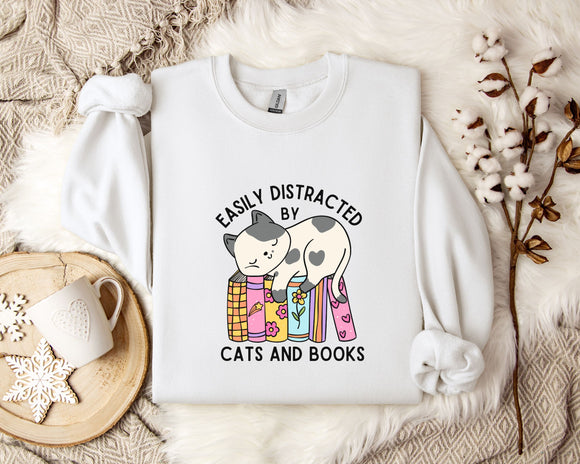 a white t-shirt with a graphic design of a cat sitting on a stack of books, accompanied by the text 