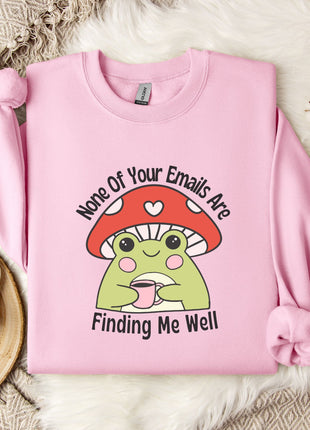 a pink sweatshirt with a mushroom character and text, placed on a bed with a white blanket and a mug.