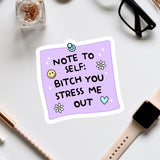 a purple sticky note with a humorous message, surrounded by various office supplies and accessories such as a pair of glasses, a pen, and a watch.