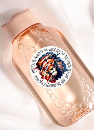 A clear glass bottle with a label featuring a lion's head and the text "You be proud of the work you do, the person you make it into".
