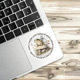 a sticker with a frog on a mushroom, placed on a laptop keyboard.