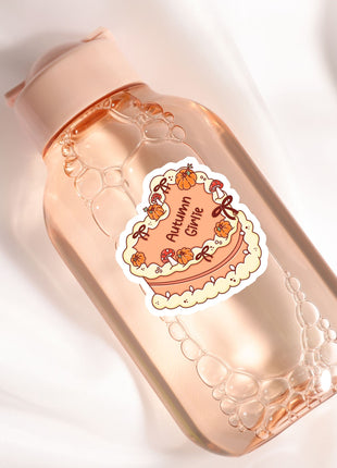 A bottle of soap with a label that says "Autumn Girl" and features a cake and pumpkins.