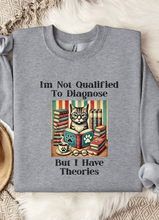 a gray sweatshirt with a humorous text and an illustration of a cat surrounded by books and a cup of coffee.