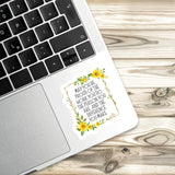 A sticker with a quote about pride and work is placed on the edge of a laptop keyboard.