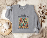 a gray sweatshirt with a graphic design of a cat surrounded by books, along with the text "Easily Distracted By Cats & Books".