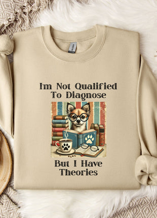 a beige sweatshirt with a humorous text and an illustration of a dog wearing glasses and a book, placed on a bed with a white blanket and a mug.