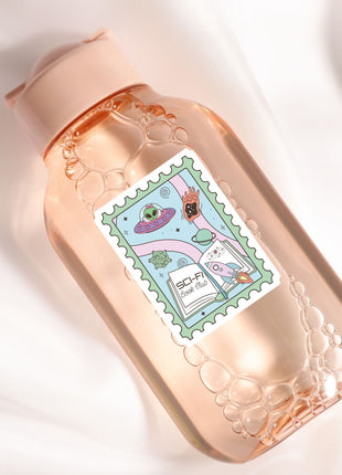A pink bottle with a label featuring a cartoon illustration of a hand holding a book, surrounded by bubbles.