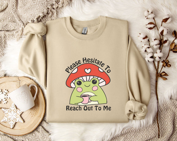 a beige sweater with a mushroom character and text, along with a mug, a plant, and some white flowers on a white fur rug.