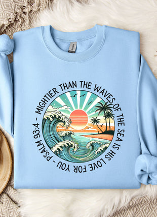 a light blue sweater with a picture of a sunset and palm trees on it