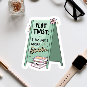 a table topped with a pile of books next to a pair of glasses
