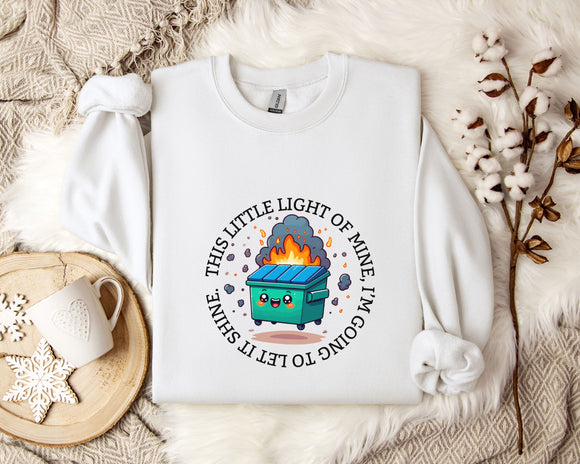 a white t-shirt with a graphic design depicting a fire-breathing trash can, surrounded by a circular design with the text 