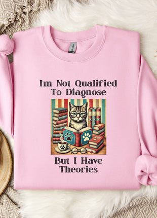 A pink sweatshirt with a cat illustration and text, placed on a white fur rug with a mug and a branch of cotton flowers nearby.