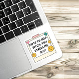 A sticker with a humorous message is placed on a laptop keyboard.