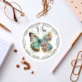 a clock with a butterfly on it next to a notepad