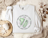 a white sweatshirt with a green sneaker on it