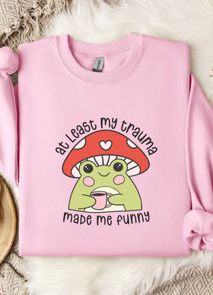 A pink sweatshirt with a mushroom graphic and text, placed on a white fur rug.