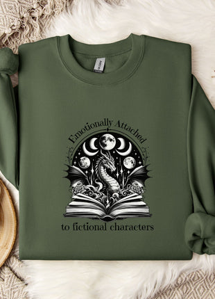 a green sweatshirt with a graphic design on it, placed on a bed with a white blanket and a white mug.