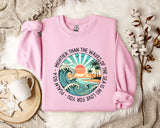 a pink sweater with a picture of a sunset on it