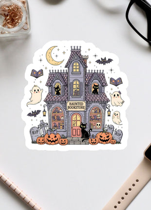 a sticker depicting a spooky house with Halloween-themed decorations, including a crescent moon, bats, pumpkins, and a ghost.