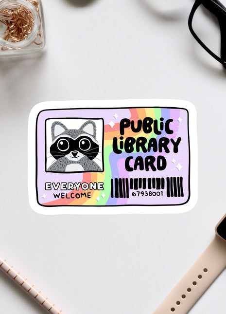 a sticker with a raccoon and the text "Public Library Card" on a white background.