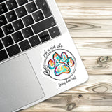 A sticker with a paw print and the text "Just a girl who loves her cat" is placed on a laptop keyboard.