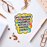 a sticker with a colorful design and text, surrounded by various office supplies such as a pen, a pair of glasses, and a notebook.