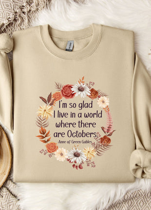 A beige sweatshirt with a floral wreath design and a quote printed on it, along with a mug, a branch of cotton bolls, and a snowflake ornament.