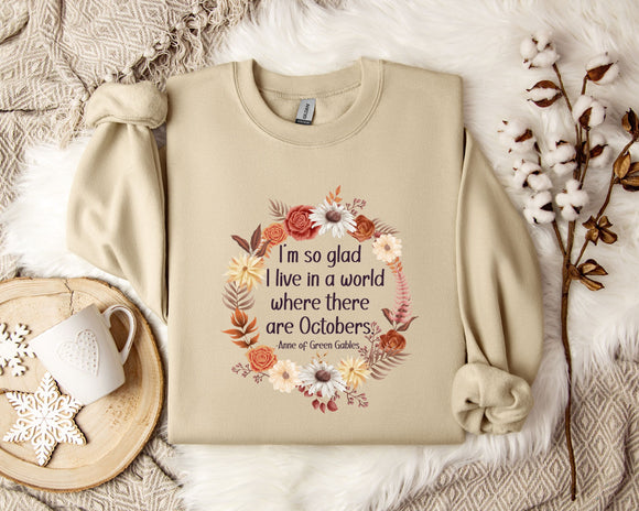 A beige sweatshirt with a floral wreath design and a quote printed on it, along with a mug, a branch of cotton bolls, and a snowflake ornament.
