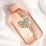 A pink bottle with a heart-shaped sticker featuring various fall-themed illustrations, such as pumpkins, leaves, and other seasonal objects.