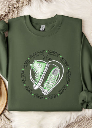 a green sweatshirt with a pair of sneakers on it