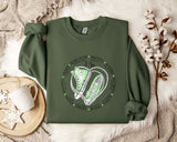 a green sweatshirt with a pair of sneakers on it