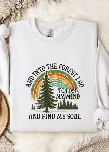 A white sweatshirt with a graphic design featuring a tree, a rainbow, and the text "AND INTO THE FOREST I GO TO LOSE MY MIND AND FIND MY SOUL".