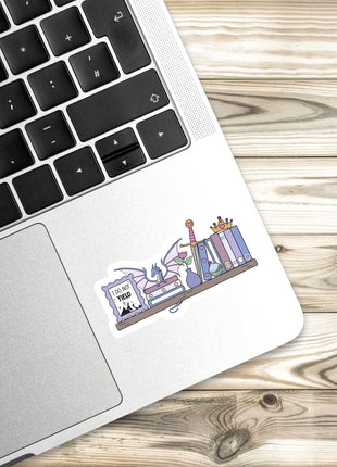 a sticker with a cartoon illustration of a bookshelf on a laptop keyboard.