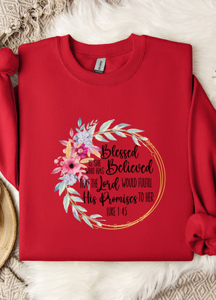 A red sweater with a floral design and text printed on it, placed on a white fur rug.