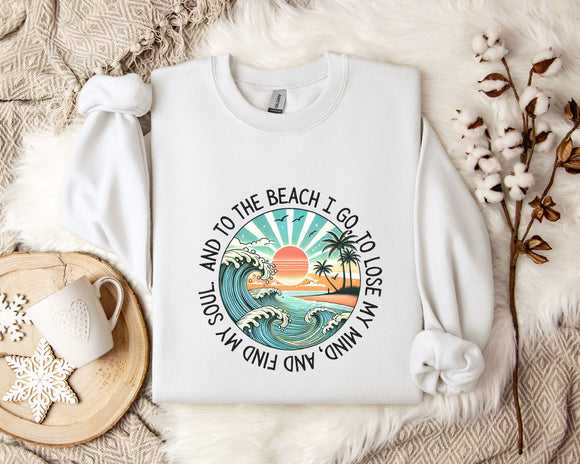 A white sweatshirt with a graphic design depicting a beach scene, along with the text 
