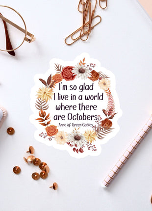 a sticker with a quote, surrounded by various office supplies such as pens, a notebook, and a pair of glasses.